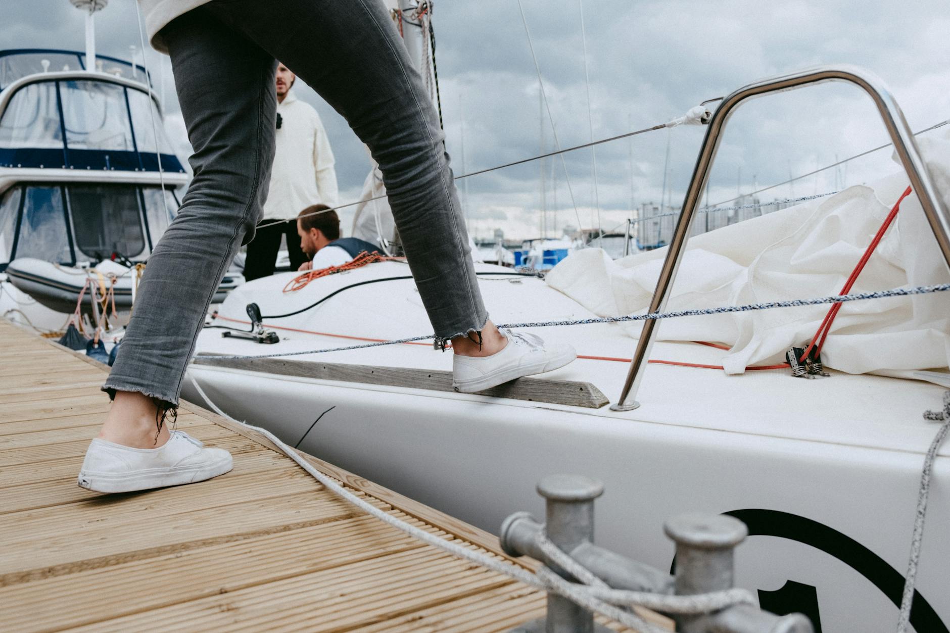 person in gray pants and black socks standing on white boat